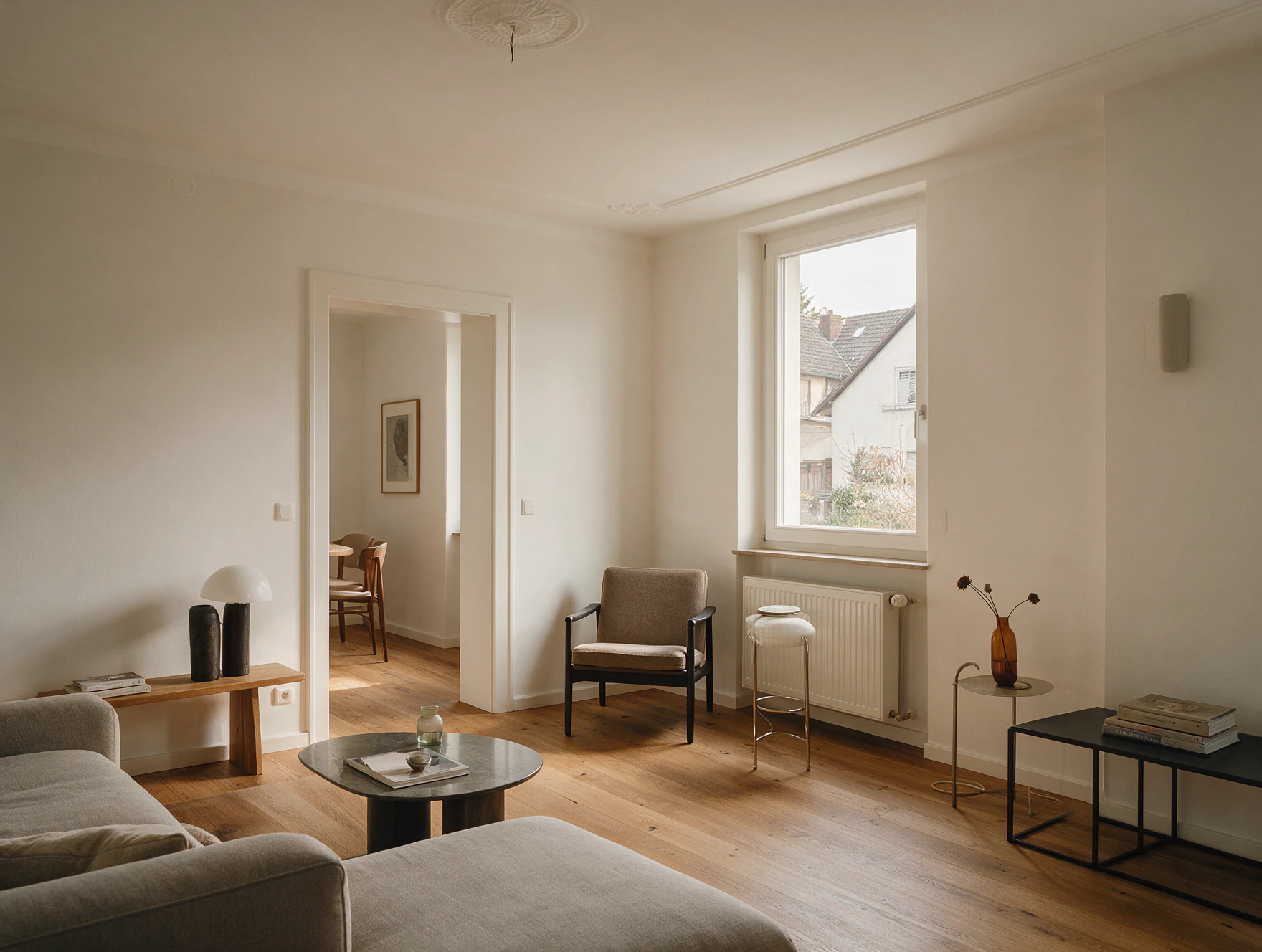 Fertig renovierter Wohnraum mit hellen Wänden, Sprossenfenster und Eichenparkett
